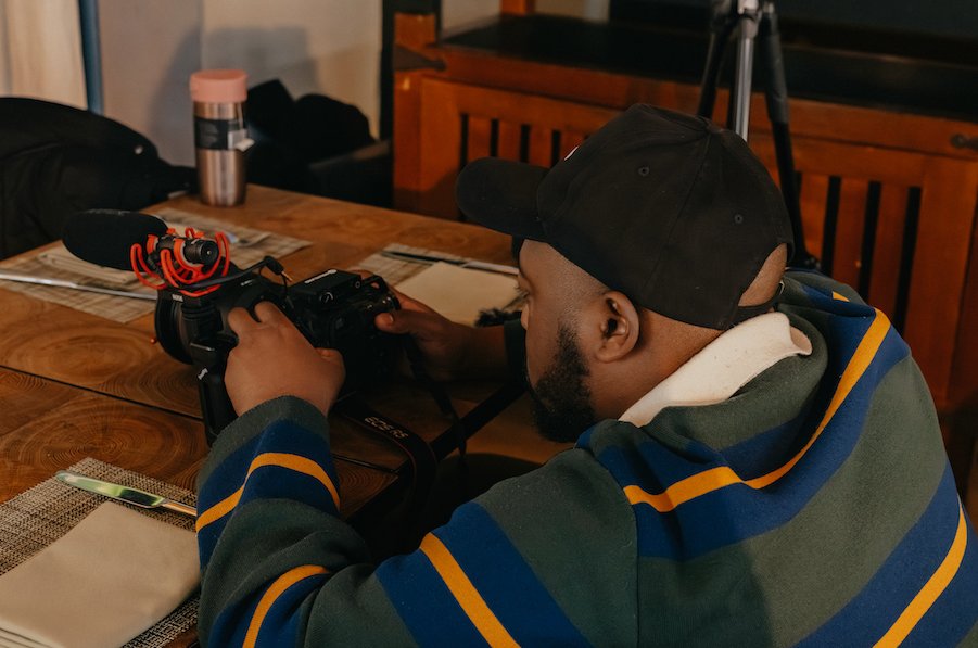 Videographer operating a camera indoors during a filming session. Lionel Odelana